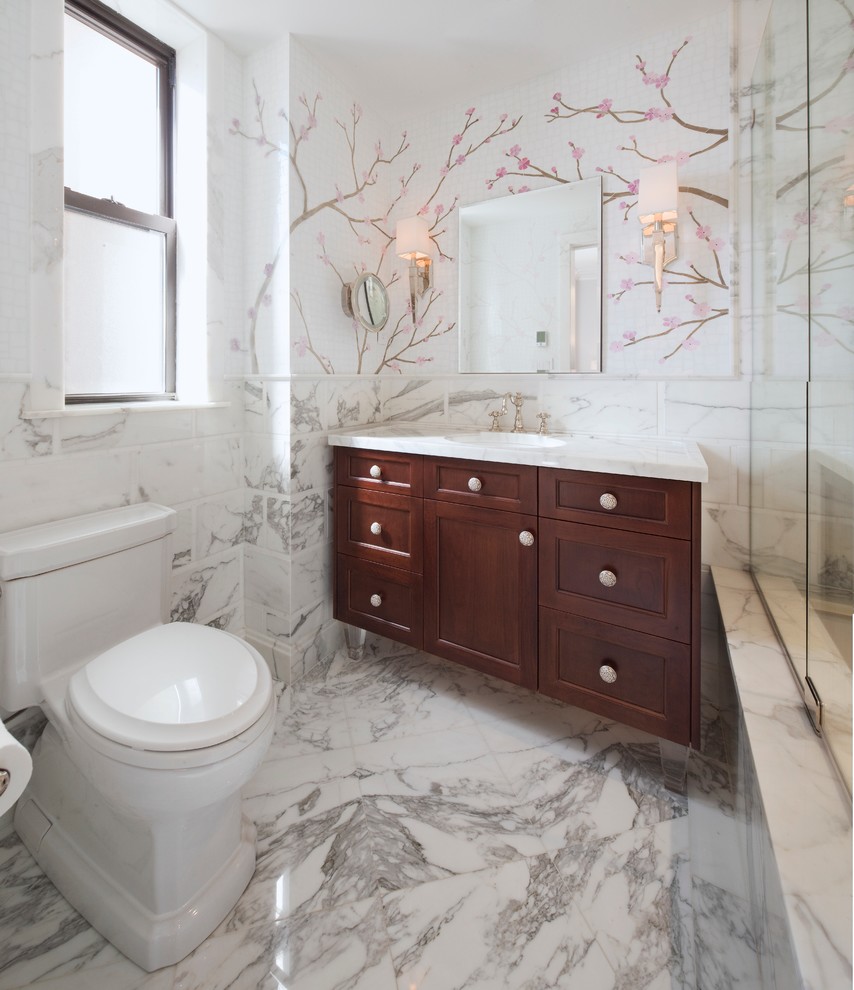 ニューヨークにあるトラディショナルスタイルのおしゃれな浴室 (アンダーカウンター洗面器、落し込みパネル扉のキャビネット、濃色木目調キャビネット、アンダーマウント型浴槽、シャワー付き浴槽	、一体型トイレ	、白いタイル) の写真