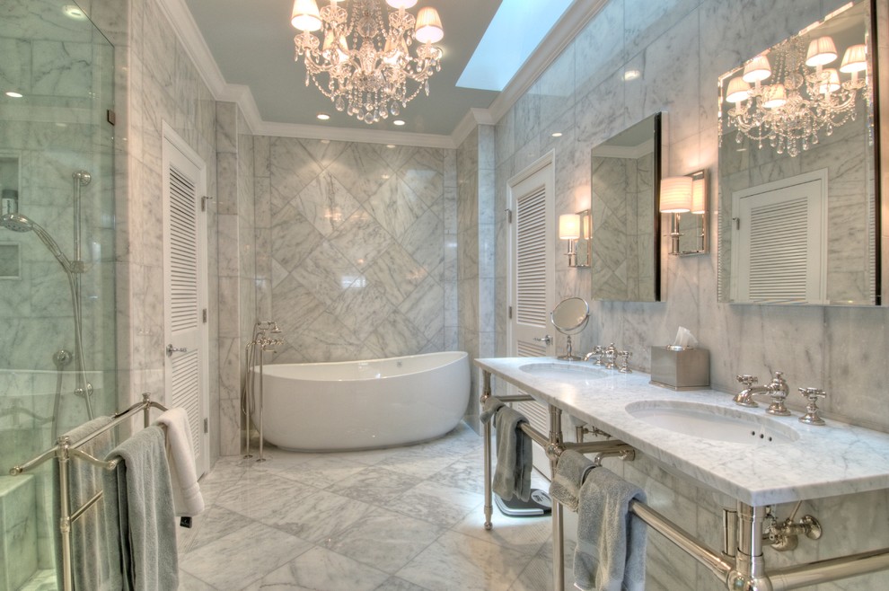 Elegant marble tile freestanding bathtub photo in Tampa with a console sink and marble countertops