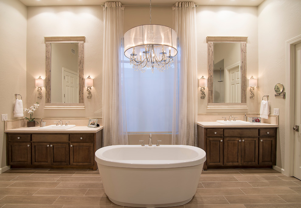 Foto de cuarto de baño clásico con lavabo encastrado, armarios con paneles con relieve, puertas de armario de madera en tonos medios y bañera exenta