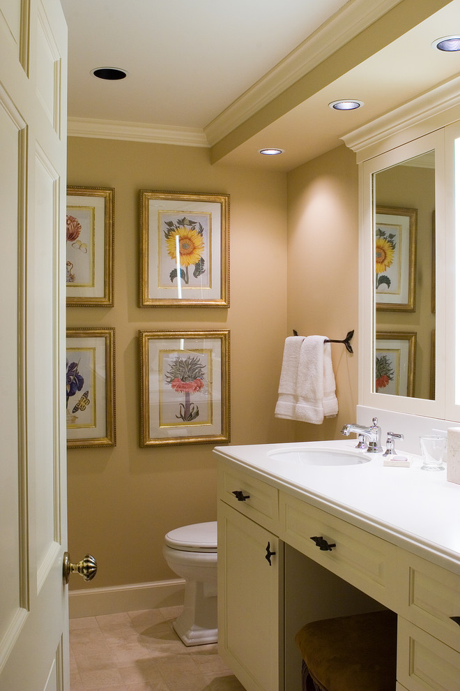 Foto di una stanza da bagno tradizionale con lavabo sottopiano, ante con bugna sagomata e ante beige