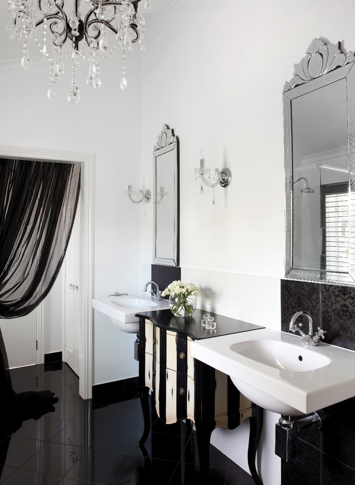 Cette image montre une salle de bain traditionnelle avec un lavabo suspendu, un carrelage noir et un sol noir.
