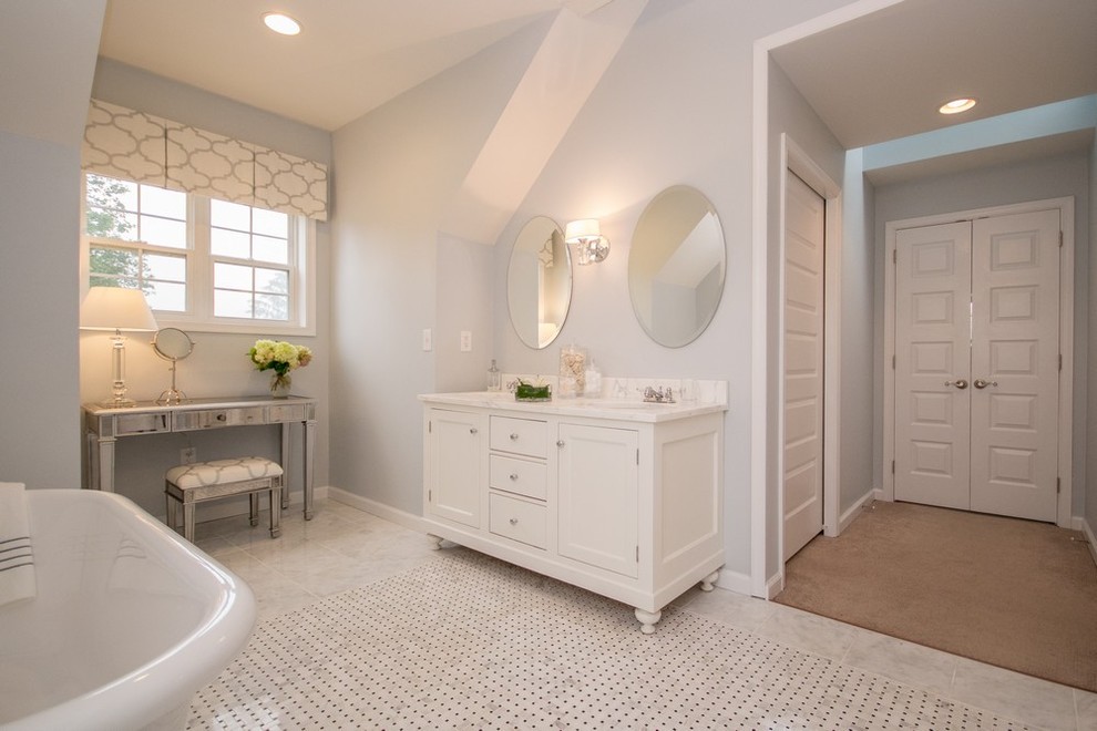 Inspiration pour une salle de bain traditionnelle avec une baignoire sur pieds et un plan de toilette en marbre.