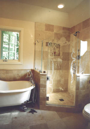 Esempio di una stanza da bagno tradizionale di medie dimensioni con vasca con piedi a zampa di leone, doccia ad angolo, piastrelle beige, piastrelle in pietra, pareti beige e pavimento in marmo