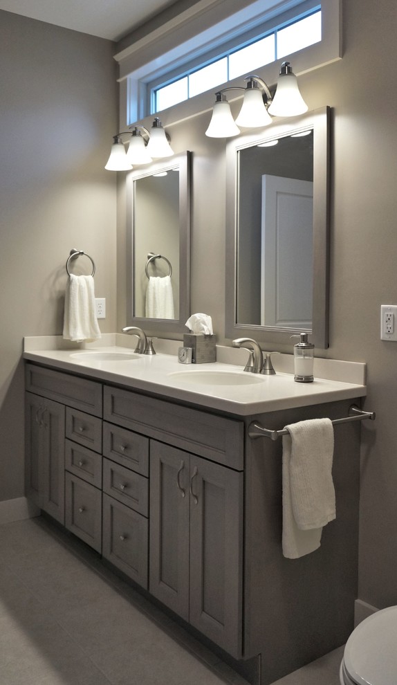 Foto di una stanza da bagno padronale tradizionale di medie dimensioni con ante grigie, piastrelle grigie, lavabo integrato, ante con riquadro incassato, pareti grigie e doccia alcova