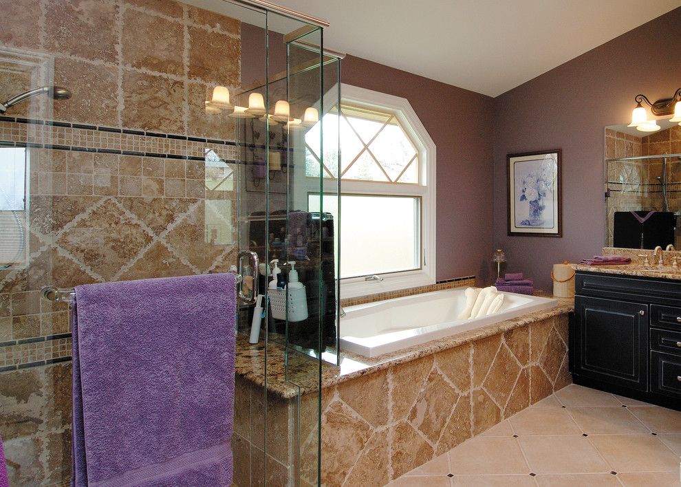 Modelo de cuarto de baño principal tradicional grande con lavabo integrado, armarios con paneles con relieve, puertas de armario negras, bañera encastrada, ducha esquinera, baldosas y/o azulejos marrones y paredes púrpuras