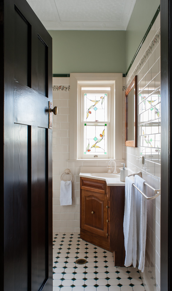 Пример оригинального дизайна: ванная комната в классическом стиле с монолитной раковиной, фасадами с выступающей филенкой, темными деревянными фасадами, белой плиткой, керамической плиткой, зелеными стенами и полом из керамической плитки