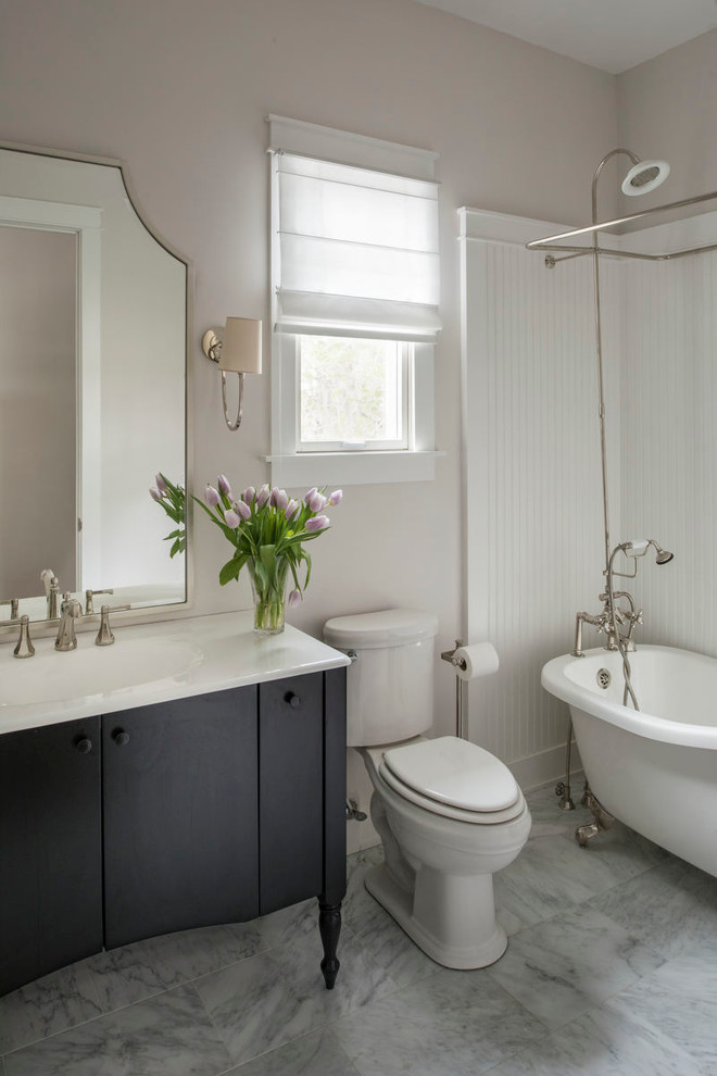 Inspiration för ett mellanstort lantligt badrum, med möbel-liknande, svarta skåp, ett fristående badkar, en dusch/badkar-kombination, en toalettstol med separat cisternkåpa, beige väggar, marmorgolv, ett integrerad handfat och bänkskiva i akrylsten
