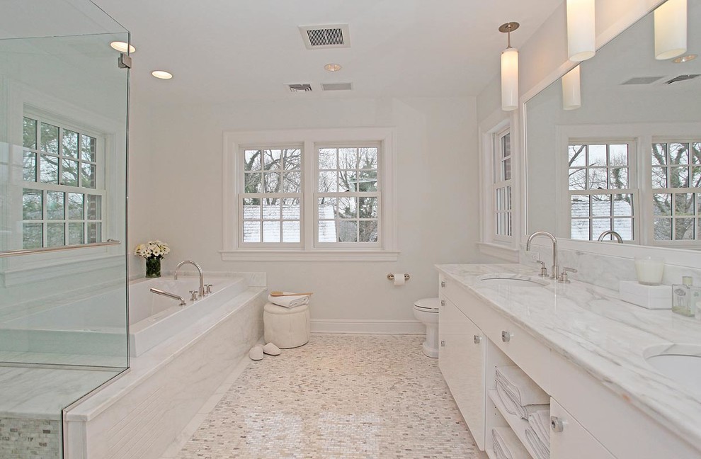 Ispirazione per una stanza da bagno tradizionale con ante lisce, ante bianche, vasca da incasso, doccia ad angolo, pareti bianche, pavimento con piastrelle a mosaico e lavabo sottopiano