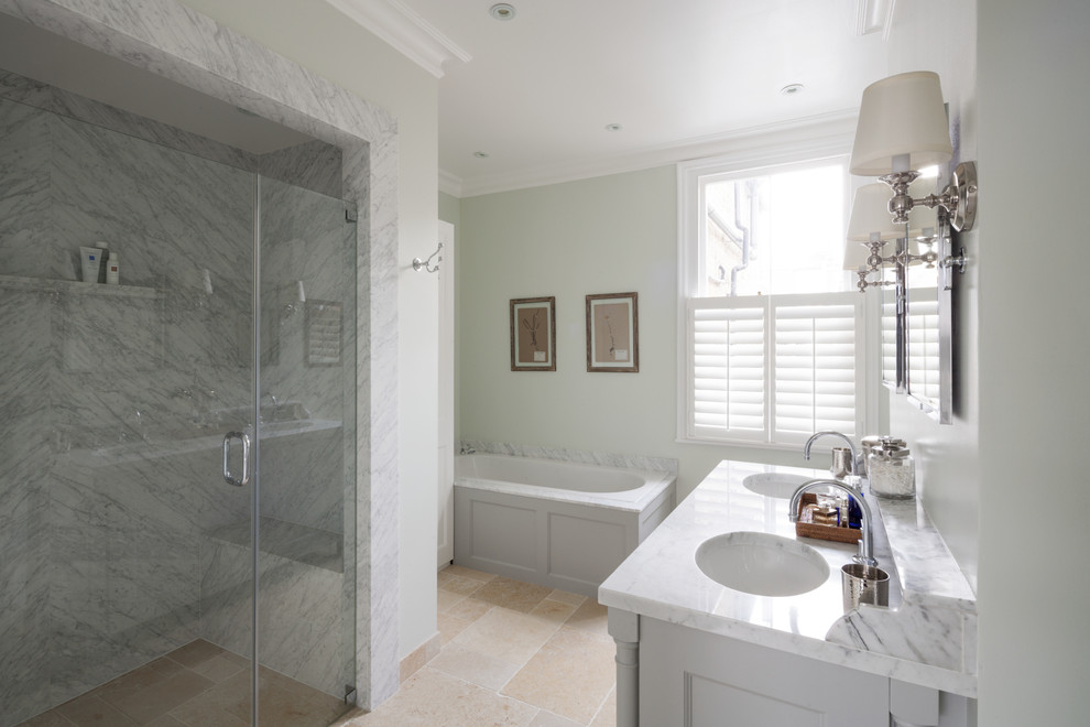 This is an example of a medium sized classic ensuite bathroom in London with a submerged sink, recessed-panel cabinets, marble worktops, a built-in bath, a built-in shower, a one-piece toilet, green walls, limestone flooring and grey cabinets.