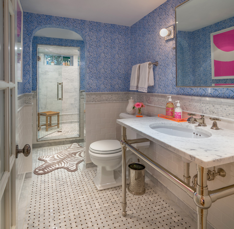 Cette image montre une douche en alcôve principale traditionnelle avec WC séparés, un carrelage blanc, un carrelage métro, un mur bleu, un sol multicolore, une cabine de douche à porte battante et un lavabo encastré.