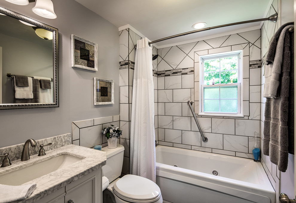 Classic bathroom in St Louis with a submerged sink, recessed-panel cabinets, white cabinets, an alcove bath, a shower/bath combination, a two-piece toilet and white tiles.