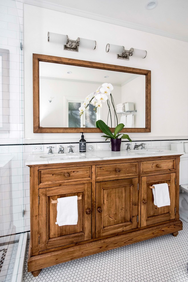 Réalisation d'une salle de bain principale tradition en bois brun de taille moyenne avec un carrelage noir et blanc, des carreaux de porcelaine, un mur blanc, un sol en carrelage de terre cuite, un lavabo encastré, un plan de toilette en marbre, un plan de toilette blanc, un sol blanc et un placard avec porte à panneau encastré.