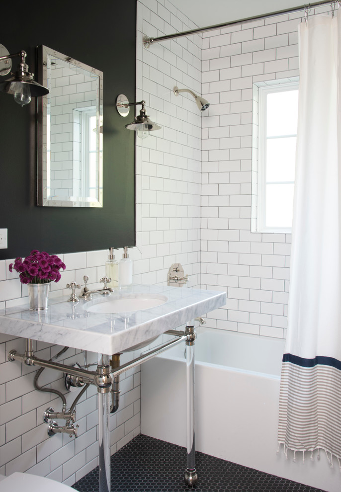 На фото: главная ванная комната в классическом стиле с мраморной столешницей, плиткой кабанчик, душем над ванной, консольной раковиной, полом из мозаичной плитки, ванной в нише, черными стенами, черно-белой плиткой и акцентной стеной