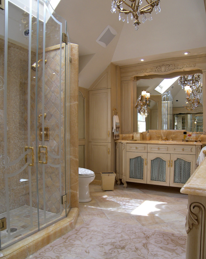 Foto de cuarto de baño clásico grande con lavabo encastrado, armarios tipo mueble, puertas de armario beige, encimera de ónix, bañera encastrada, ducha empotrada, sanitario de dos piezas, baldosas y/o azulejos beige y baldosas y/o azulejos de piedra