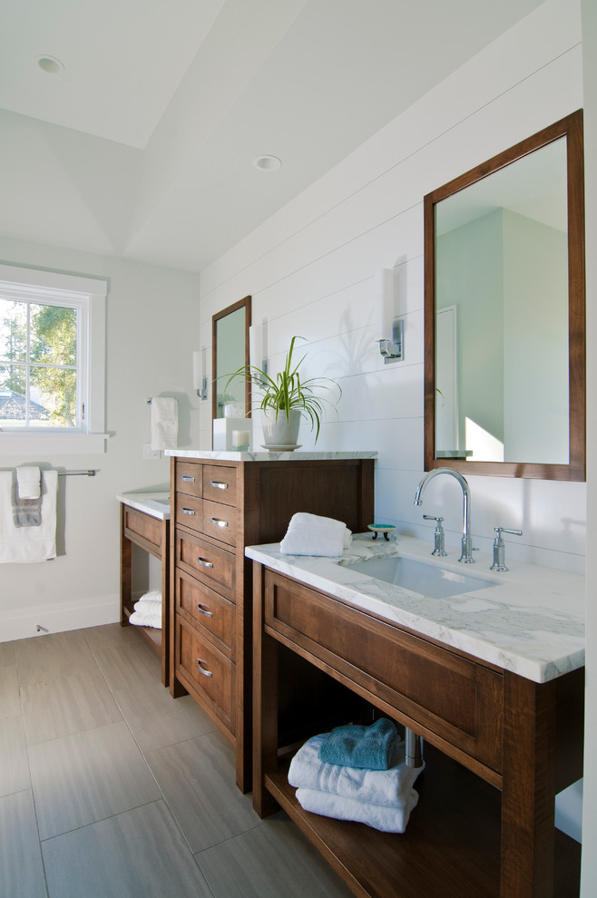 Cette photo montre une salle de bain chic en bois foncé avec un lavabo encastré, un carrelage gris et un placard à porte shaker.