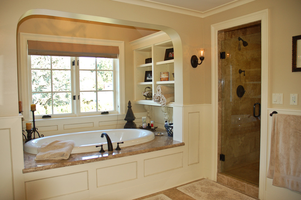 Foto de cuarto de baño principal clásico de tamaño medio con encimera de mármol, bañera empotrada, paredes beige, puertas de armario blancas, ducha empotrada y baldosas y/o azulejos beige