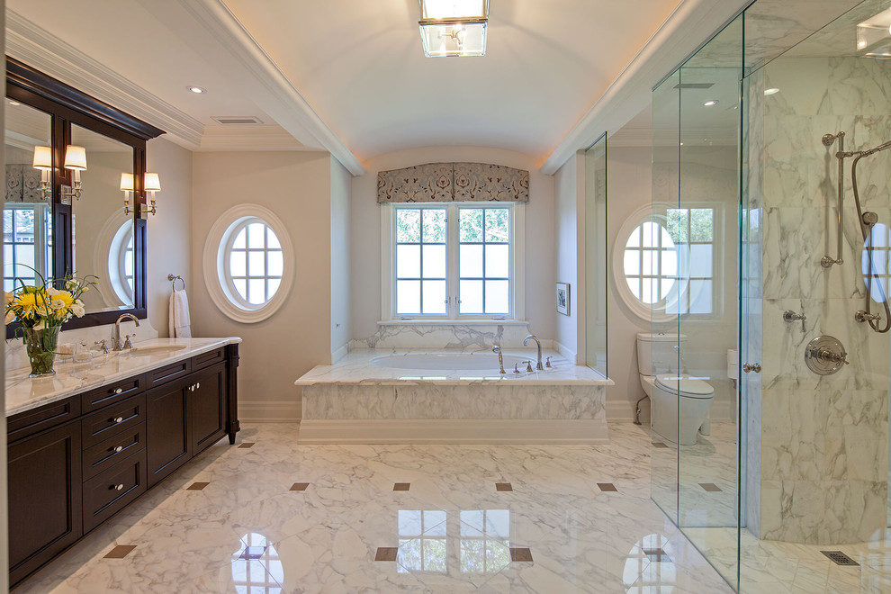 Idées déco pour une douche en alcôve classique avec une baignoire en alcôve, du carrelage en marbre et un plan de toilette beige.