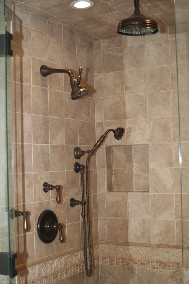 Idée de décoration pour une douche en alcôve tradition avec un carrelage beige, des carreaux de céramique et une cabine de douche à porte battante.