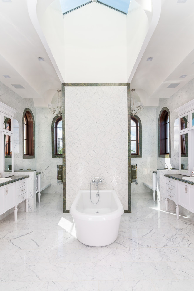 Elegant master white tile freestanding bathtub photo in Miami with white cabinets