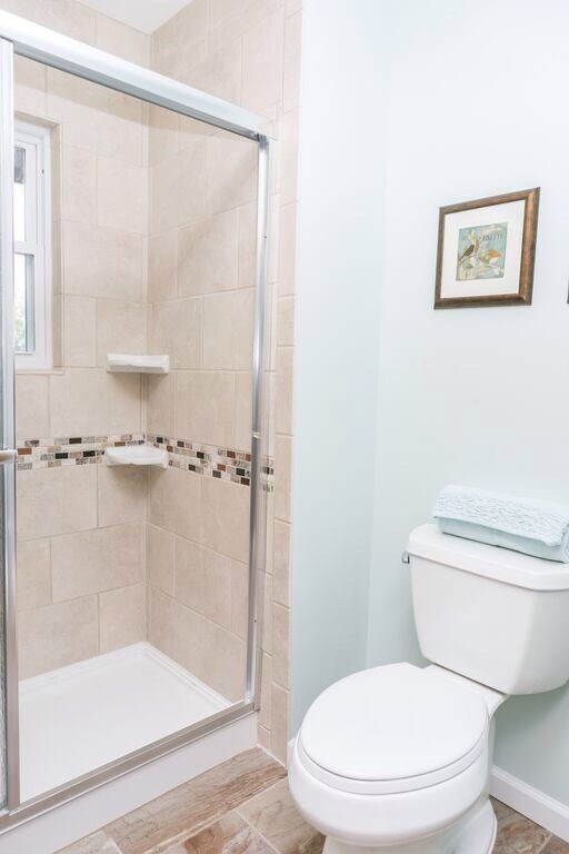 Klassisk inredning av ett litet badrum med dusch, med skåp i shakerstil, skåp i mörkt trä, en dusch i en alkov, en toalettstol med separat cisternkåpa, beige kakel, keramikplattor, vita väggar, ett undermonterad handfat och bänkskiva i kalksten
