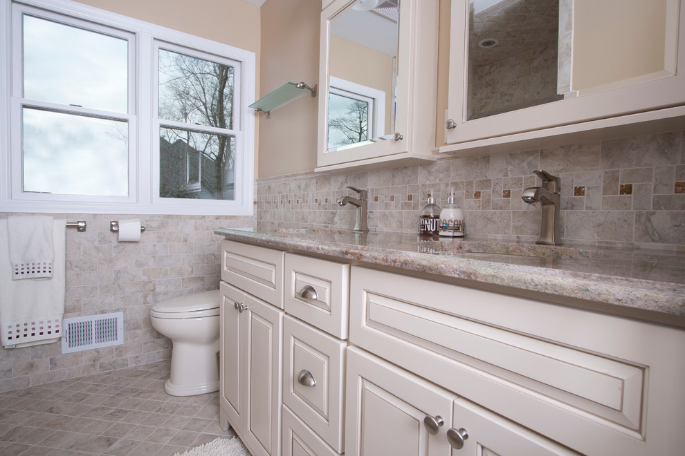 Idéer för att renovera ett mellanstort vintage badrum med dusch, med luckor med upphöjd panel, vita skåp, en toalettstol med hel cisternkåpa, beige kakel, brun kakel, grå kakel, stenkakel, beige väggar, klinkergolv i keramik, ett undermonterad handfat och granitbänkskiva