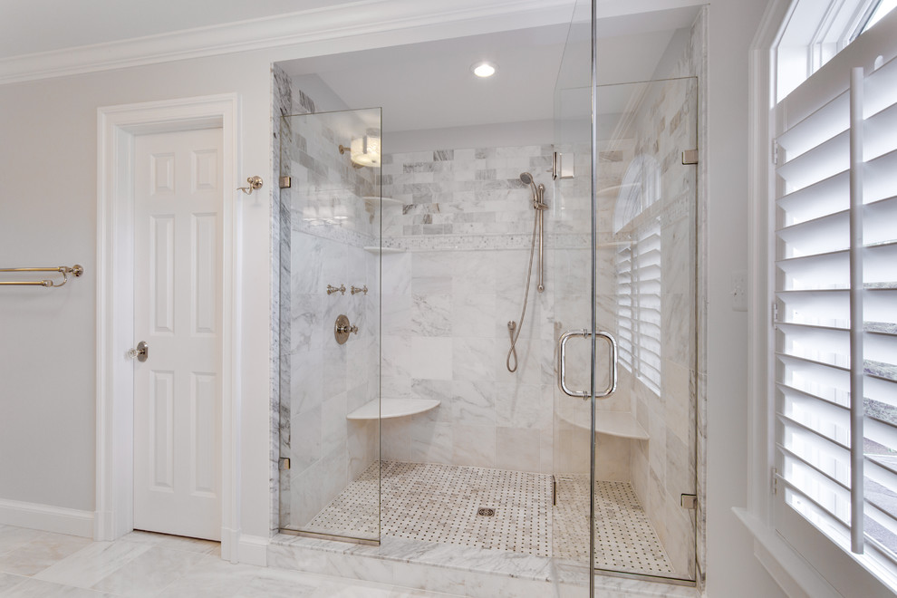 Cette photo montre une grande salle de bain chic avec un placard avec porte à panneau surélevé, un plan de toilette en marbre et un sol en marbre.