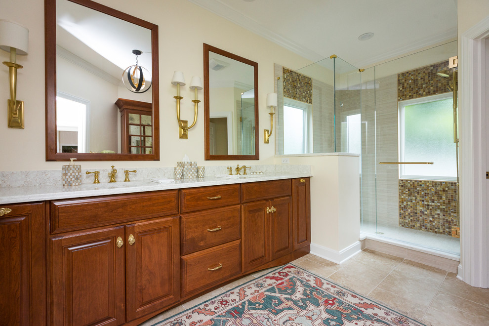 Inspiration for a mid-sized timeless master beige tile and porcelain tile porcelain tile and beige floor corner shower remodel in Cincinnati with raised-panel cabinets, medium tone wood cabinets, a one-piece toilet, beige walls, an undermount sink, quartzite countertops and a hinged shower door