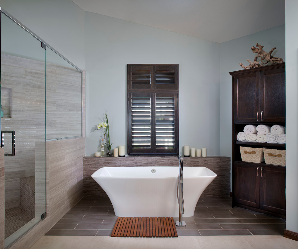 Ispirazione per una grande stanza da bagno padronale moderna con ante in stile shaker, ante in legno bruno, vasca freestanding, doccia ad angolo, pareti blu e pavimento con piastrelle in ceramica