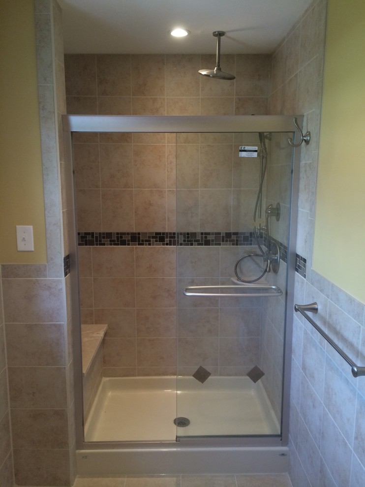 Exempel på ett mellanstort klassiskt badrum, med möbel-liknande, svarta skåp, en dusch i en alkov, en toalettstol med separat cisternkåpa, gula väggar, travertin golv, ett väggmonterat handfat och granitbänkskiva