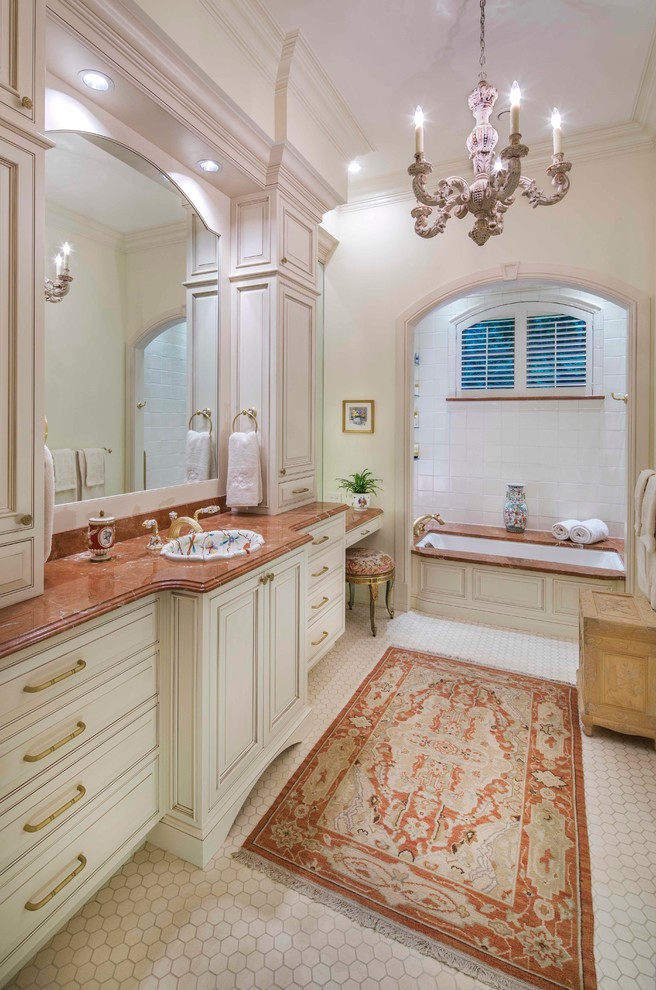 На фото: ванная комната в классическом стиле с накладной раковиной, фасадами с выступающей филенкой, белыми фасадами, полновстраиваемой ванной, белой плиткой, белыми стенами и коричневой столешницей