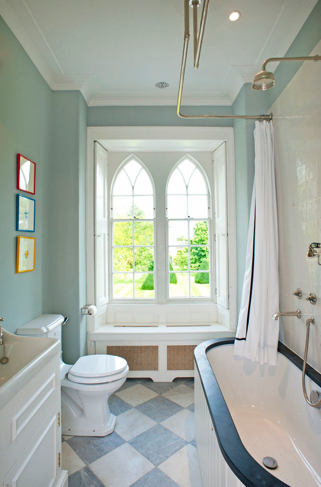На фото: ванная комната в классическом стиле с белыми фасадами, душем над ванной, унитазом-моноблоком, синими стенами и шторкой для ванной