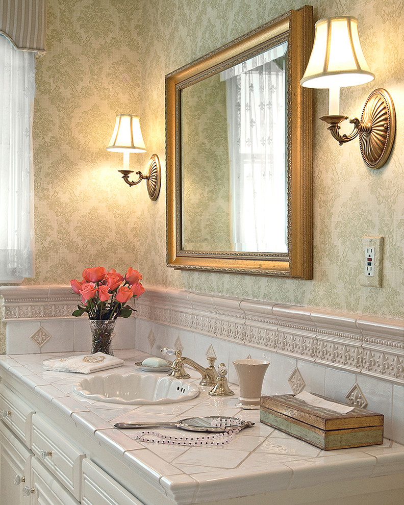 На фото: маленькая ванная комната в классическом стиле с зелеными стенами, фасадами с выступающей филенкой, бежевыми фасадами, ванной в нише, душем над ванной, бежевой плиткой, белой плиткой, керамической плиткой, полом из керамической плитки, душевой кабиной, накладной раковиной, столешницей из плитки, белым полом и душем с раздвижными дверями для на участке и в саду с