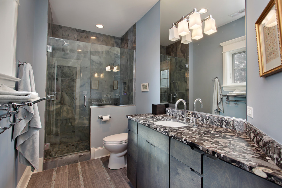 Foto di una stanza da bagno classica con lavabo sottopiano, ante lisce, ante blu, doccia alcova e piastrelle grigie