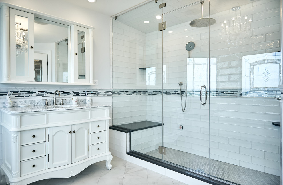 ニューヨークにあるトラディショナルスタイルのおしゃれな浴室 (白いキャビネット、アルコーブ型シャワー、グレーのタイル、白いタイル、白い壁、アンダーカウンター洗面器、グレーの床、開き戸のシャワー、グレーの洗面カウンター、落し込みパネル扉のキャビネット) の写真