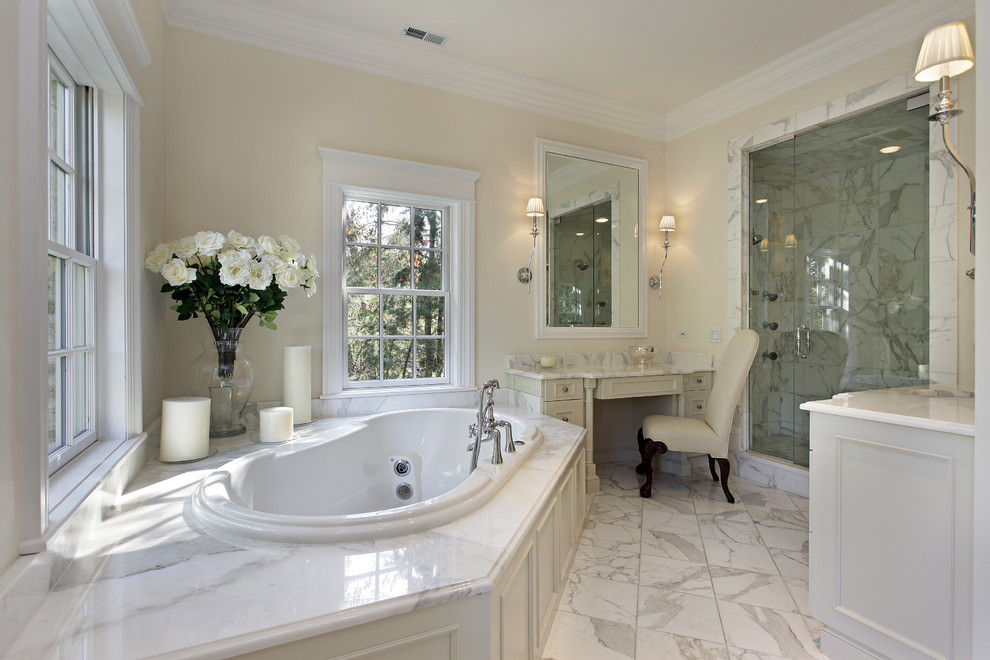 Inredning av ett klassiskt badrum, med beige skåp, marmorbänkskiva, en dusch i en alkov, vit kakel, stenkakel, gula väggar, luckor med infälld panel och ett platsbyggt badkar