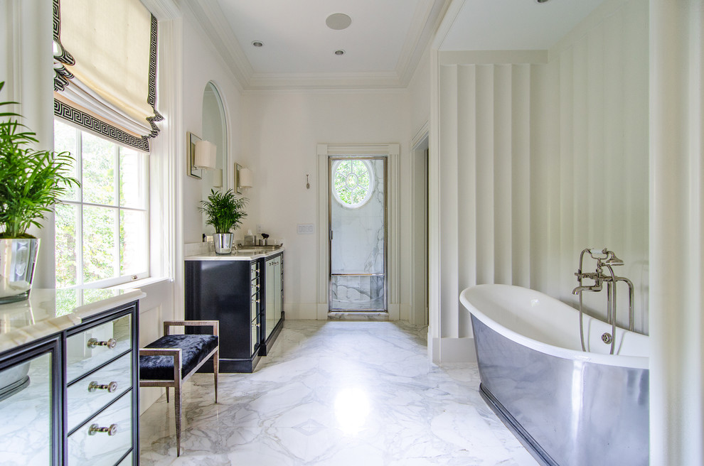 Diseño de cuarto de baño clásico con lavabo encastrado, armarios con paneles con relieve, puertas de armario beige, encimera de mármol, bañera exenta y baldosas y/o azulejos beige