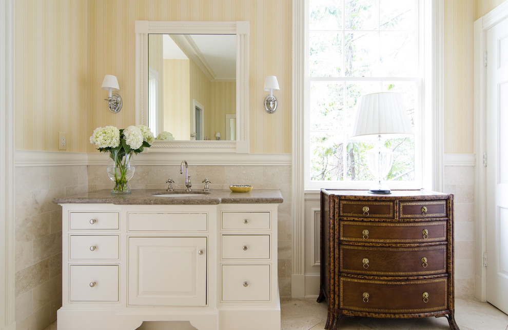 Ispirazione per una stanza da bagno tradizionale con lavabo sottopiano, ante con bugna sagomata, piastrelle beige e ante bianche