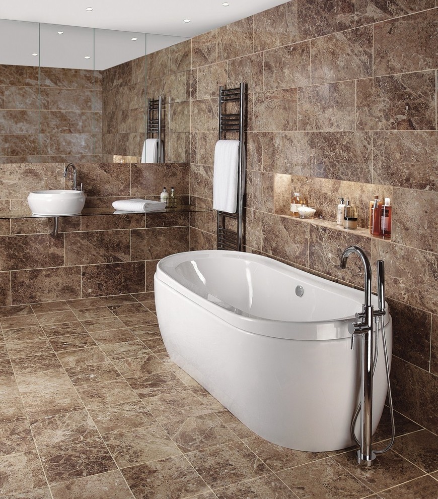Exempel på ett stort klassiskt badrum, med ett fristående handfat, vita skåp, bänkskiva i glas, ett fristående badkar, brun kakel, porslinskakel, bruna väggar och klinkergolv i porslin