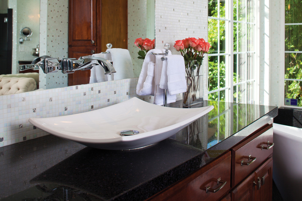 Large traditional ensuite bathroom in Miami with a vessel sink, raised-panel cabinets, medium wood cabinets, recycled glass worktops, a freestanding bath, an alcove shower, white tiles, glass tiles and white walls.