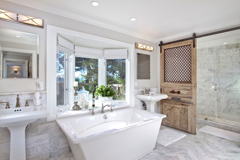 Пример оригинального дизайна: большая главная ванная комната в классическом стиле с отдельно стоящей ванной, серой плиткой, мраморной плиткой, белыми стенами, мраморным полом, раковиной с пьедесталом, белым полом, душем с раздвижными дверями и желтой столешницей