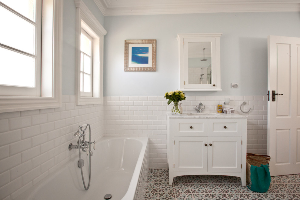 На фото: ванная комната в классическом стиле с белой плиткой, синими стенами и разноцветным полом