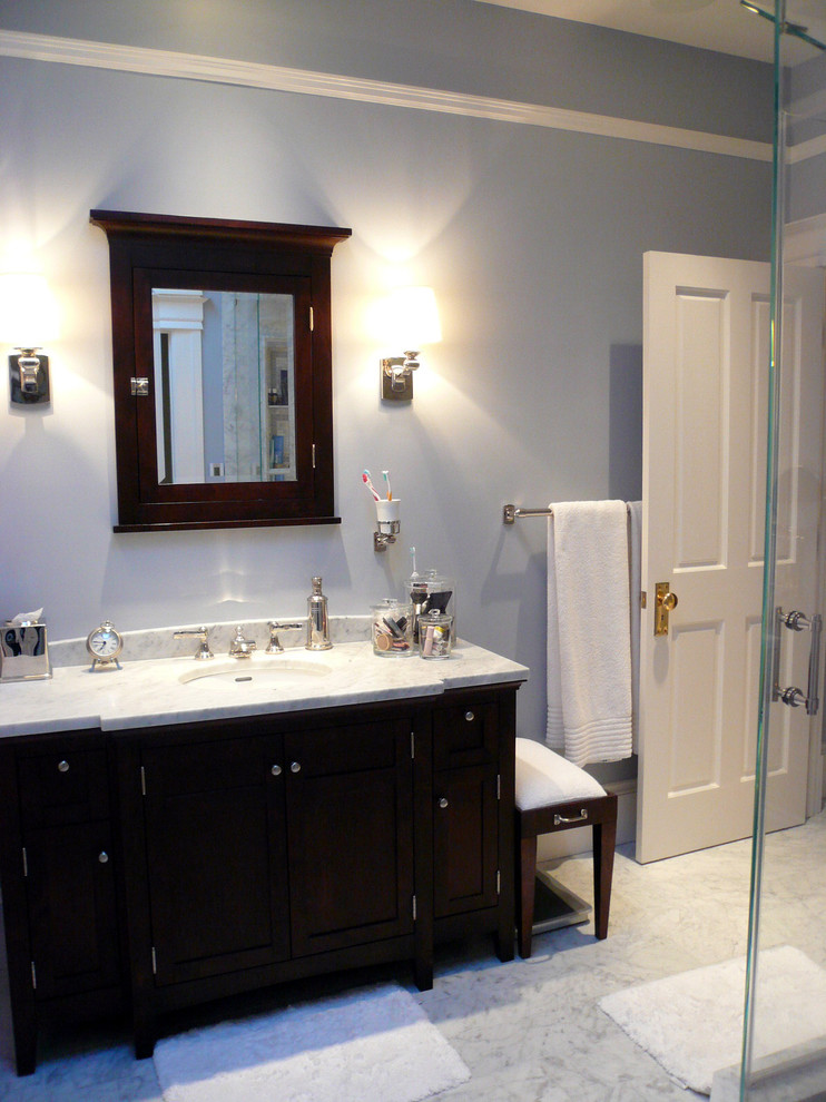 Immagine di una piccola stanza da bagno padronale chic con lavabo sottopiano, ante in legno bruno, top in marmo, doccia ad angolo, WC monopezzo, piastrelle bianche, piastrelle in pietra, pareti blu e pavimento in marmo