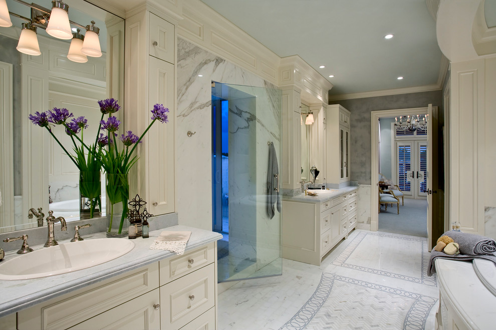 Exemple d'une salle de bain principale chic avec un lavabo intégré, un placard avec porte à panneau encastré, des portes de placard blanches, un plan de toilette en granite, une baignoire indépendante, une douche ouverte, un carrelage blanc, des dalles de pierre et un mur blanc.