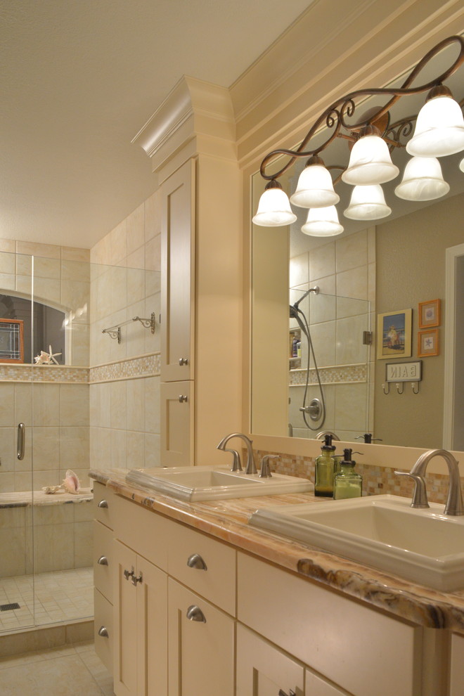 Inspiration pour une salle de bain principale traditionnelle de taille moyenne avec un lavabo posé, un placard à porte plane, des portes de placard blanches, un plan de toilette en onyx, un carrelage beige, mosaïque et un mur blanc.