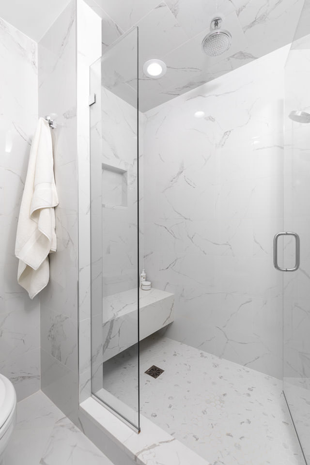 Inspiration for a large timeless master beige tile and porcelain tile porcelain tile and gray floor corner shower remodel in Detroit with shaker cabinets, white cabinets, a one-piece toilet, beige walls, an undermount sink, quartz countertops, a hinged shower door and white countertops