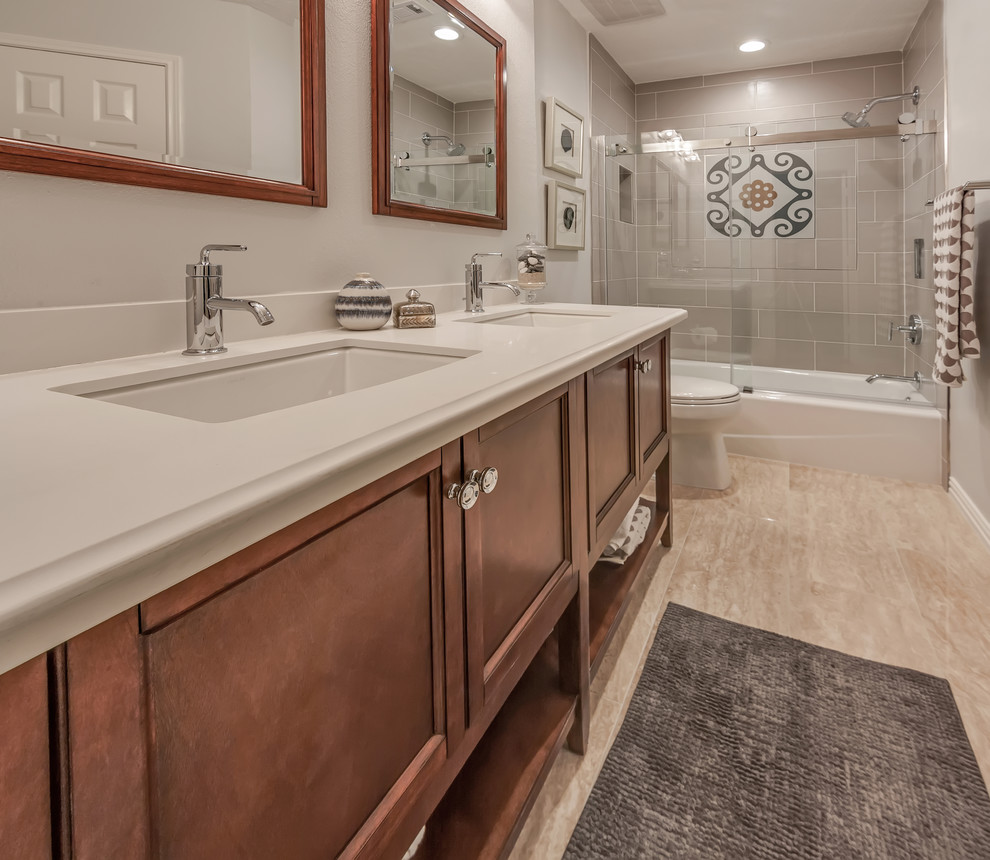 Bathroom - mid-sized mediterranean 3/4 gray tile and subway tile beige floor bathroom idea in Houston with beaded inset cabinets, medium tone wood cabinets, a two-piece toilet, white walls, an undermount sink and solid surface countertops
