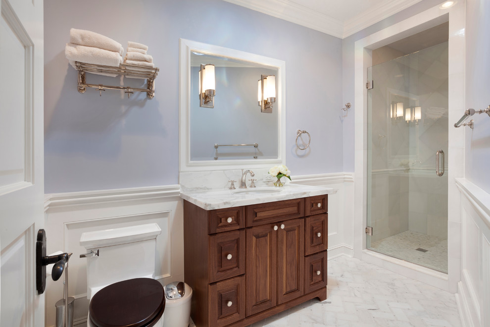 На фото: ванная комната среднего размера в классическом стиле с фасадами с утопленной филенкой, фасадами цвета дерева среднего тона, душем в нише, унитазом-моноблоком, фиолетовыми стенами, полом из керамогранита, душевой кабиной, накладной раковиной, мраморной столешницей, белым полом, душем с распашными дверями и разноцветной столешницей с
