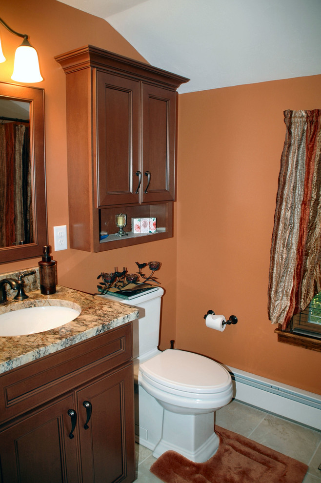 ボストンにあるお手頃価格の中くらいなトラディショナルスタイルのおしゃれな浴室 (アンダーカウンター洗面器、中間色木目調キャビネット、御影石の洗面台、分離型トイレ、ベージュのタイル、磁器タイル、オレンジの壁、磁器タイルの床、落し込みパネル扉のキャビネット、アルコーブ型浴槽、シャワー付き浴槽	、ベージュの床、シャワーカーテン) の写真
