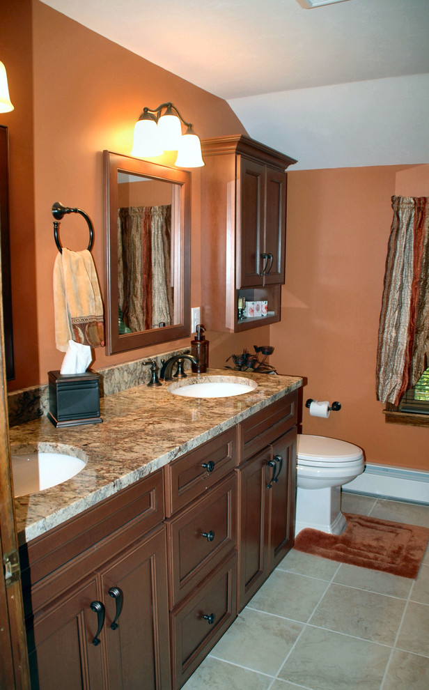 Mid-sized elegant beige tile and porcelain tile porcelain tile and beige floor bathroom photo in Boston with an undermount sink, medium tone wood cabinets, granite countertops, a two-piece toilet and orange walls