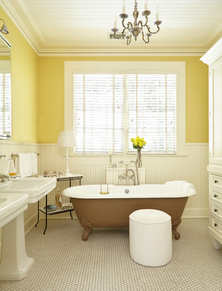 Идея дизайна: ванная комната в классическом стиле с белыми фасадами, желтыми стенами, полом из мозаичной плитки, раковиной с пьедесталом, фасадами с утопленной филенкой и ванной на ножках